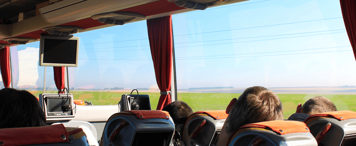 Panoramic view on a charter bus while passengers recline their seats and rest